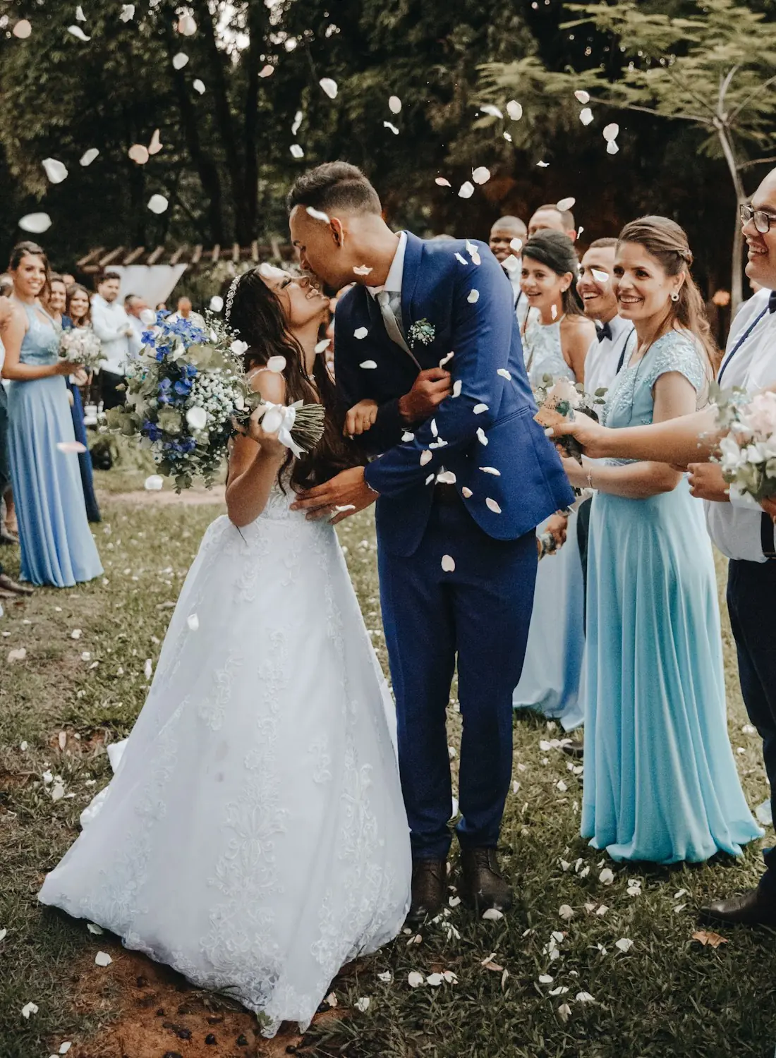 Wedding guests throwing petals as the couple kisses: the faces FotoMe AI detects are outlined